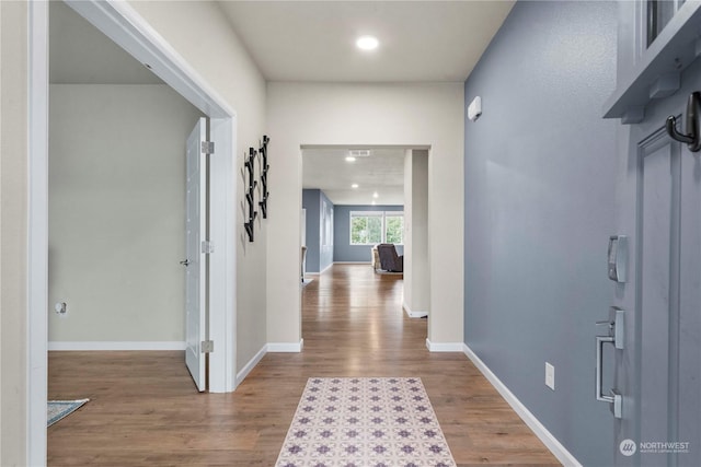 hallway with light hardwood / wood-style floors