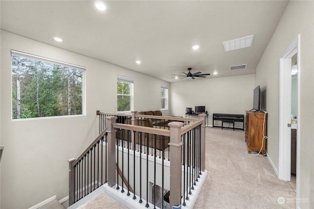 stairs featuring ceiling fan and carpet flooring