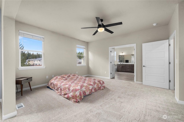 carpeted bedroom featuring ceiling fan and ensuite bath