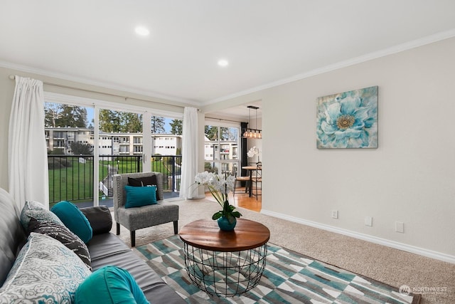 living room featuring an inviting chandelier, ornamental molding, and carpet flooring