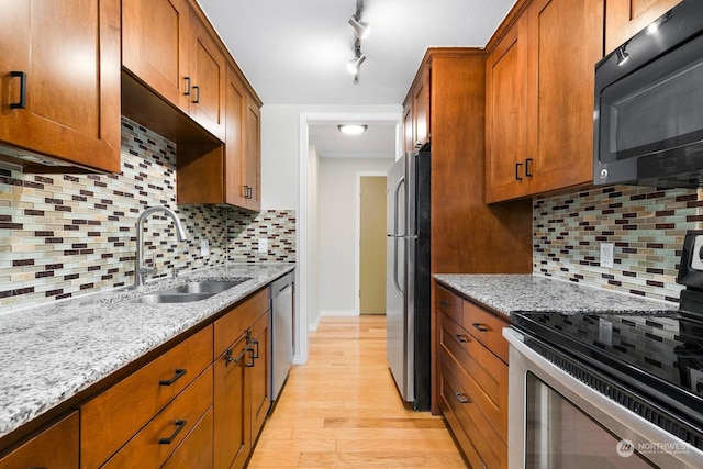 kitchen featuring sink, stainless steel appliances, light stone countertops, and backsplash