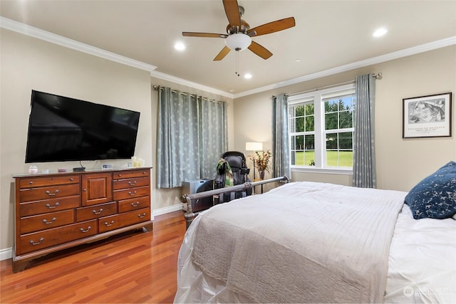 bedroom with crown molding, hardwood / wood-style flooring, and ceiling fan