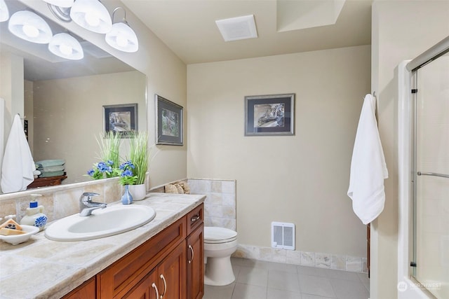 bathroom with tile patterned flooring, vanity, toilet, and walk in shower