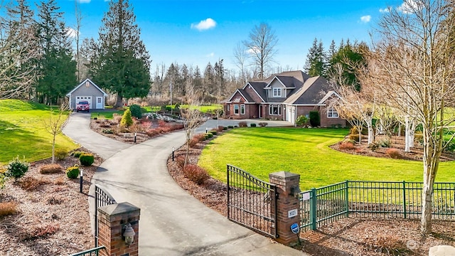 view of front of house featuring a garage, an outdoor structure, and a front lawn