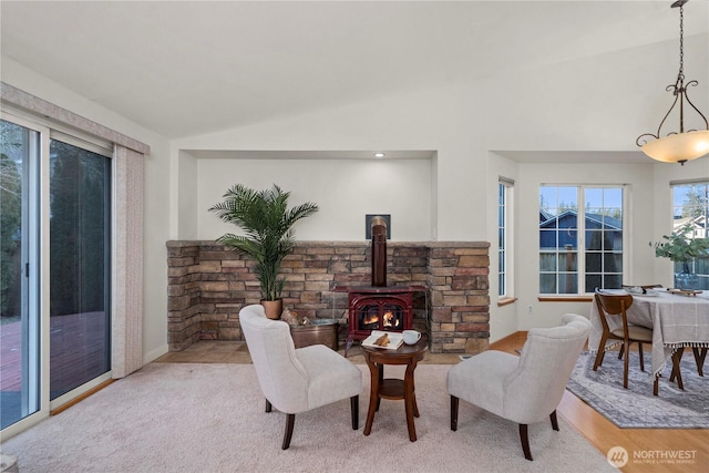 living room featuring lofted ceiling and a wood stove