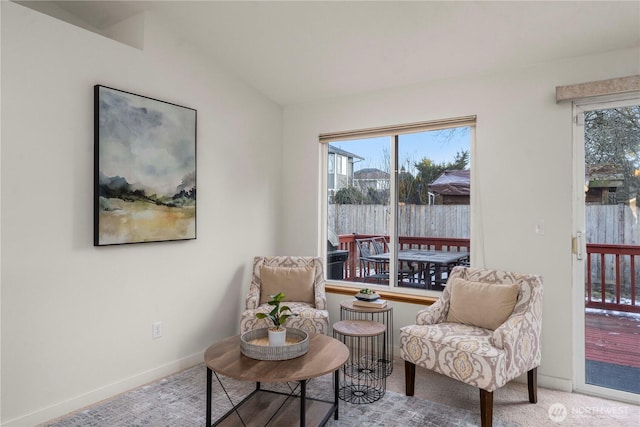 sitting room with light colored carpet and vaulted ceiling