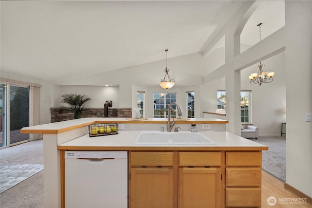 kitchen featuring an island with sink, sink, light colored carpet, white dishwasher, and an inviting chandelier