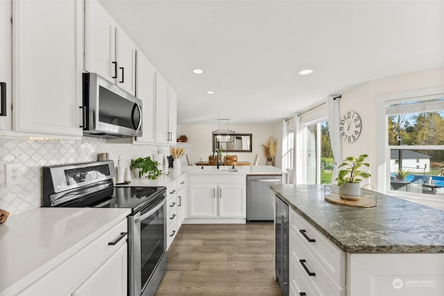 kitchen featuring appliances with stainless steel finishes, tasteful backsplash, white cabinetry, sink, and dark wood-type flooring