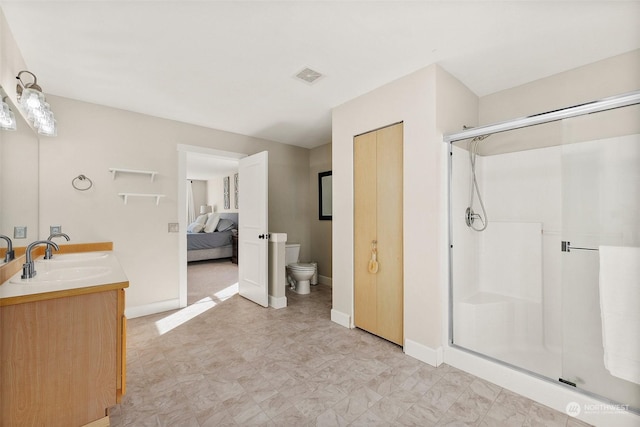 bathroom with vanity, toilet, and a shower with door