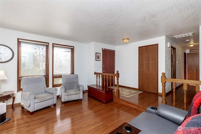 living room with wood-type flooring and a textured ceiling