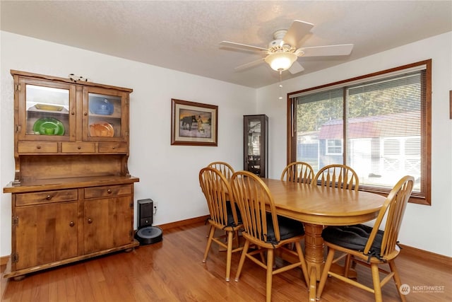 dining area with light hardwood / wood-style floors and ceiling fan