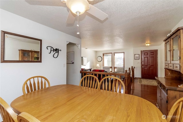 dining space featuring ceiling fan, wood-type flooring, and a textured ceiling