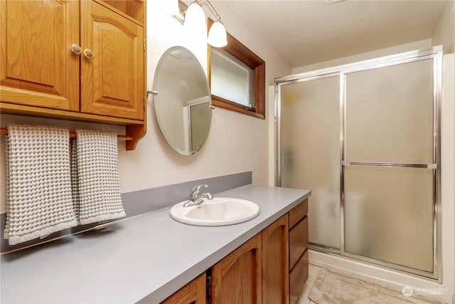 bathroom with vanity and a shower with door