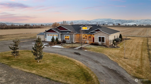 view of front of house featuring a garage, a yard, and a mountain view