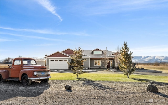 view of front of house with a garage, a mountain view, and a front yard