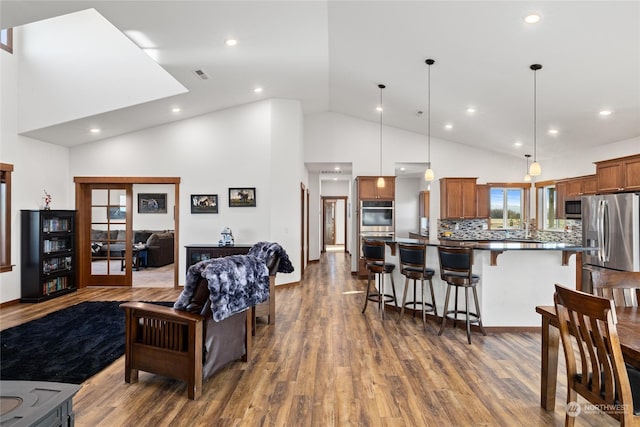 living room with dark wood-type flooring and high vaulted ceiling