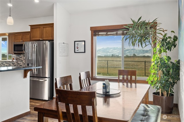 dining area with dark hardwood / wood-style flooring, a mountain view, and a wealth of natural light