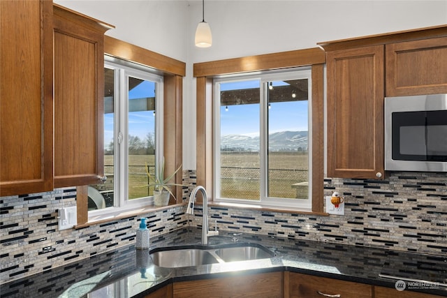 kitchen with a healthy amount of sunlight, a mountain view, and sink