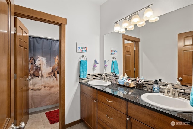 bathroom with vanity, curtained shower, tile patterned flooring, and backsplash