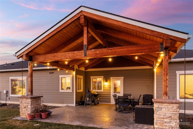 back house at dusk featuring a patio area