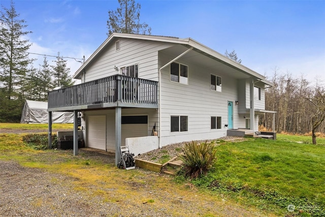 back of property featuring a garage and a lawn