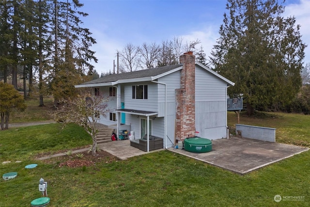 rear view of property featuring a patio and a lawn