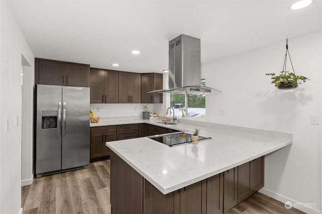 kitchen with sink, island range hood, stainless steel fridge, and kitchen peninsula