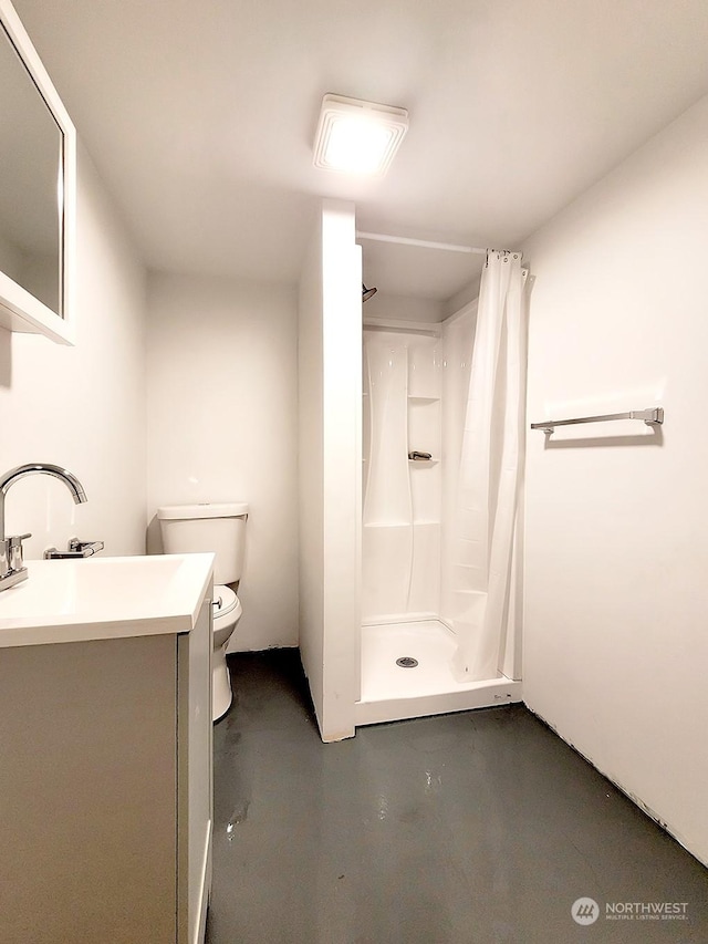 bathroom with toilet, vanity, concrete flooring, and curtained shower