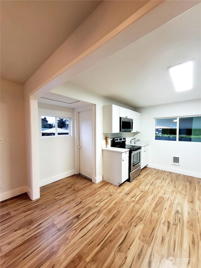 kitchen with light hardwood / wood-style flooring, stainless steel appliances, and white cabinets