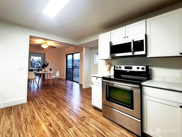 kitchen featuring electric stove, light wood-type flooring, and white cabinets