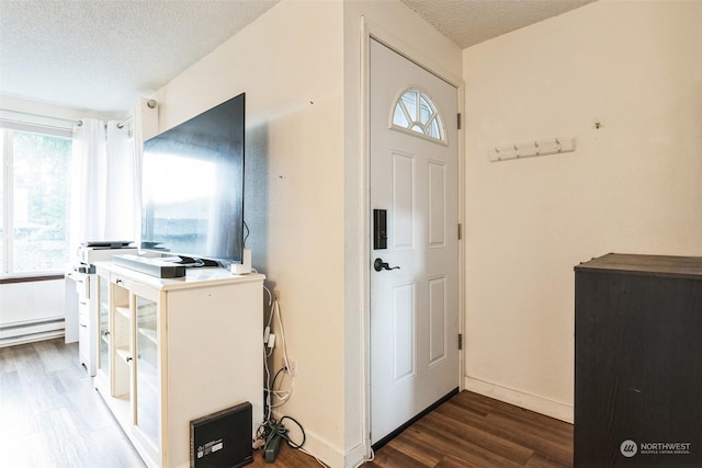 laundry room with a baseboard radiator, dark hardwood / wood-style floors, and a textured ceiling