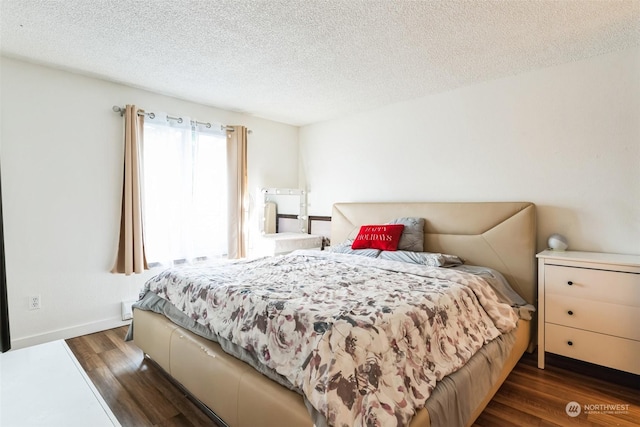 bedroom featuring dark hardwood / wood-style floors and a textured ceiling