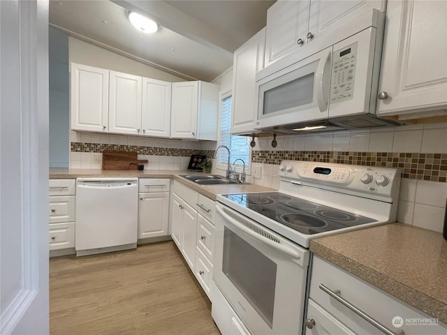 375 Union Ave SE Unit 125, Renton, WA 98059 - kitchen with white appliances, vaulted ceiling, white cabinets, light wood-type flooring, and backsplash