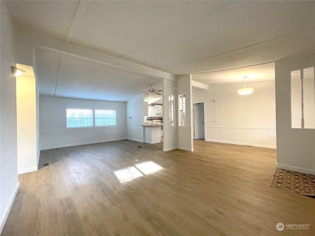 unfurnished living room with lofted ceiling with beams, wood-type flooring, and ceiling fan