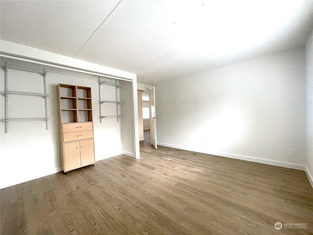 unfurnished bedroom featuring hardwood / wood-style floors and a closet