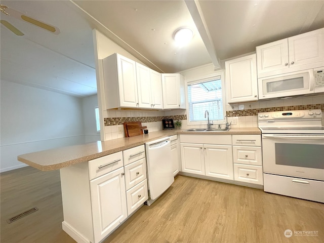 kitchen with sink, white cabinets, white appliances, and kitchen peninsula