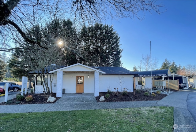 single story home with covered porch and a front yard