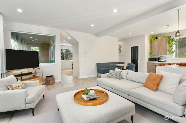 living room with light hardwood / wood-style flooring and beamed ceiling