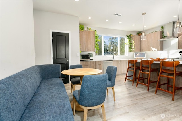 living room featuring sink and light hardwood / wood-style flooring