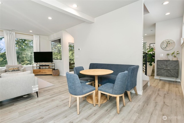 dining room with light wood-type flooring and beam ceiling