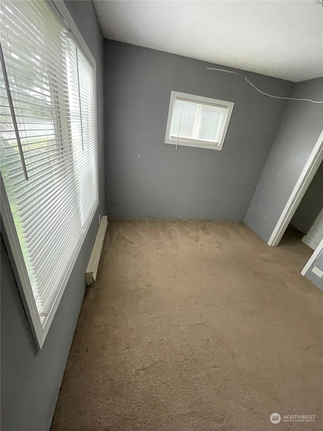 carpeted spare room with baseboard heating