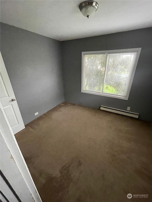 empty room with carpet floors and baseboard heating