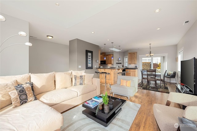 living room featuring recessed lighting, visible vents, and light wood-style flooring