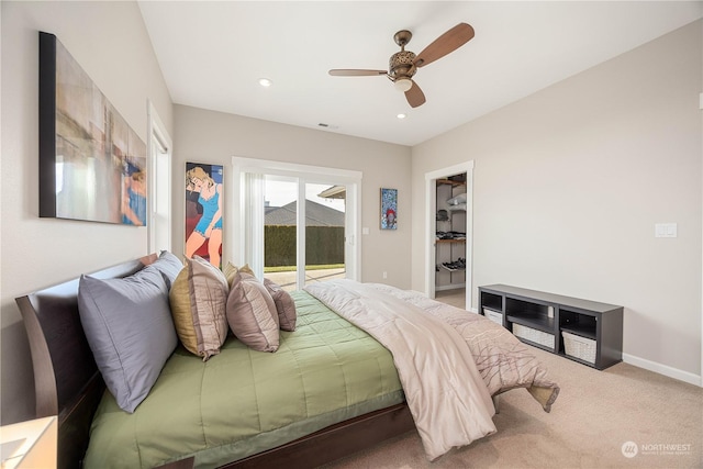 carpeted bedroom with ceiling fan, a walk in closet, and access to outside