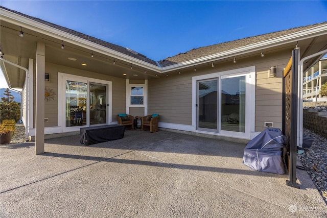 exterior space featuring a patio and roof with shingles