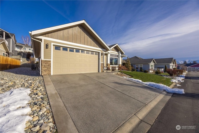 view of front of house with a garage, concrete driveway, board and batten siding, and a residential view