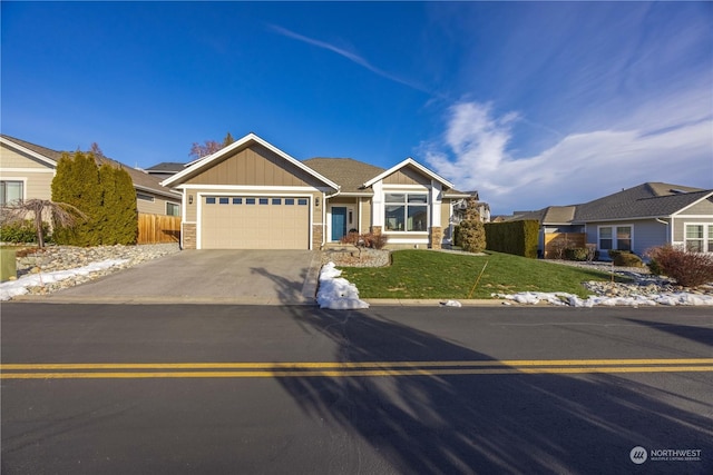 view of front facade featuring concrete driveway, board and batten siding, fence, a garage, and a front lawn