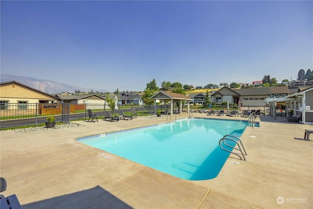 community pool featuring a residential view, fence, and a gazebo