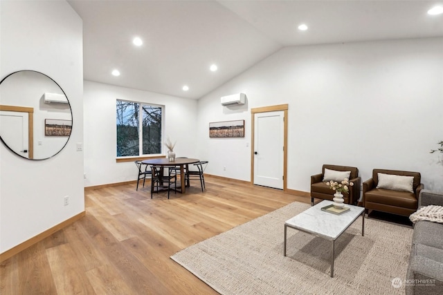 living room with lofted ceiling, light hardwood / wood-style floors, and a wall unit AC