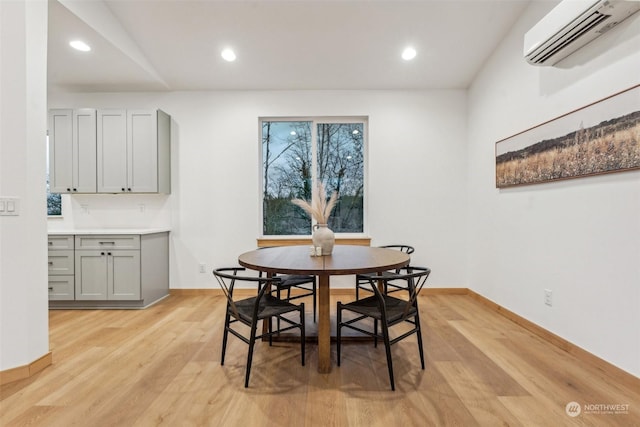 dining room featuring a wall mounted air conditioner and light wood-type flooring